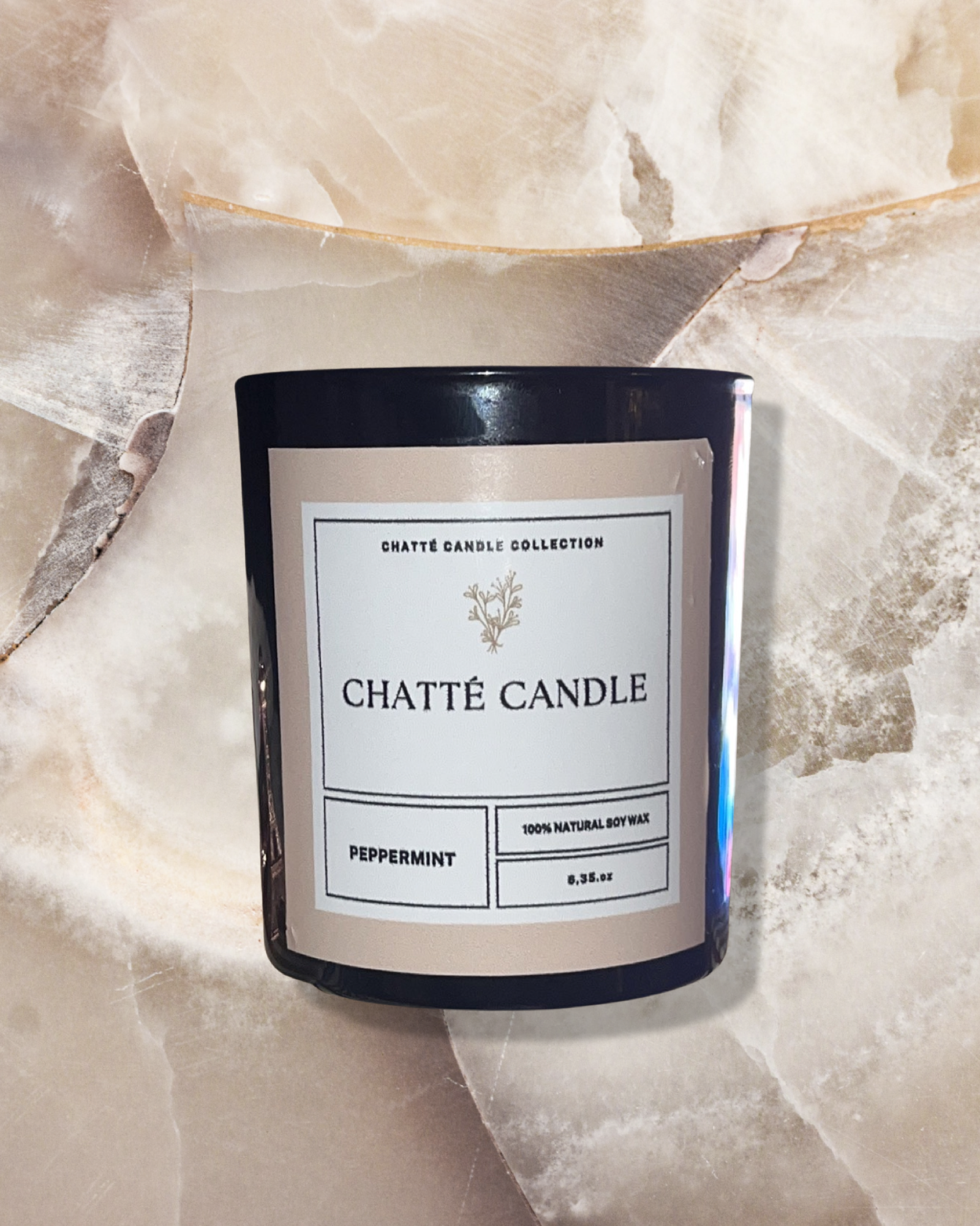 Peppermint Geur luxury aromatherapy candle in black glass jar with minimalist label, photographed against textured cream marble background. Perfect for spa and yoga aromatherapy. 100% natural soy wax candle by Chatté Candles.