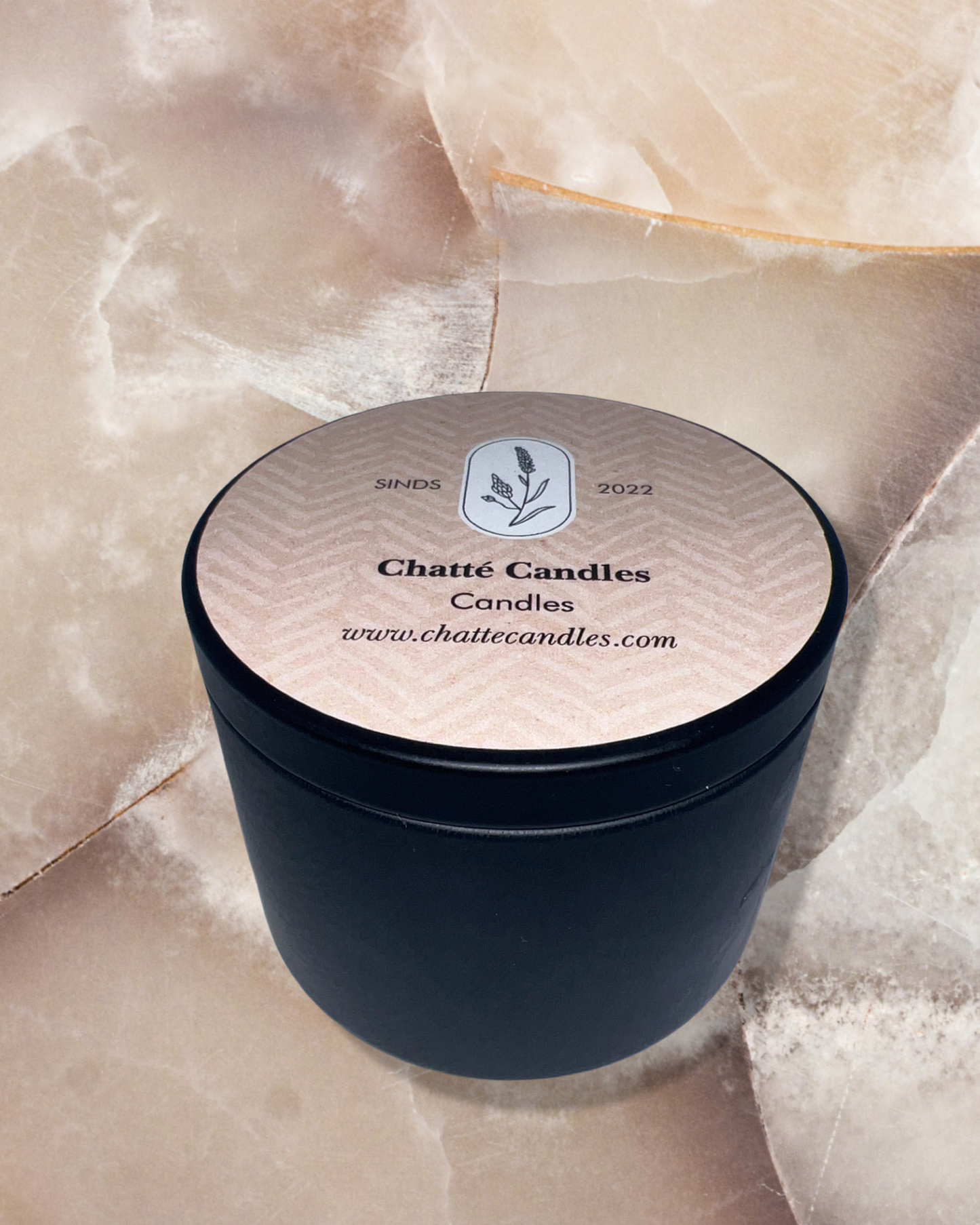 Vanilla Geur luxury scented candle in a sleek black container with rose gold lid featuring embossed chevron pattern and botanical logo design by Chatté Candles