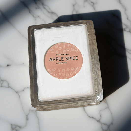 Apple Spice scented wax melt in clear clamshell packaging with soft pink label, by Chatté Candles on marble surface