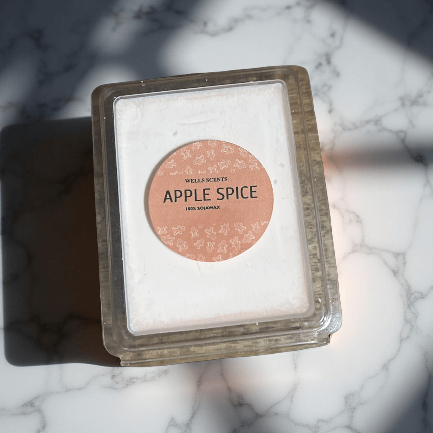 Apple Spice scented wax melts in clear clamshell packaging with peach label by Chatté Candles on marble surface