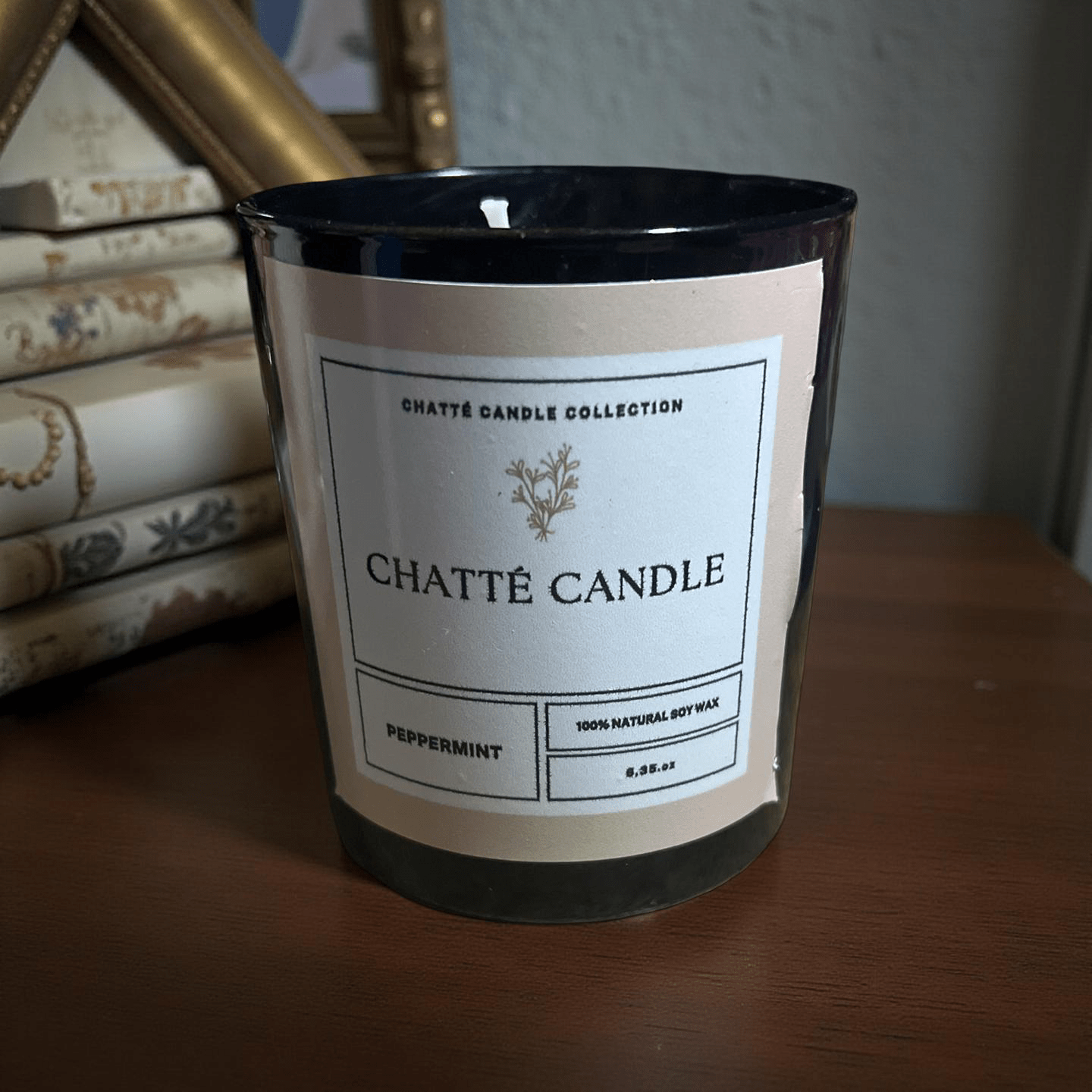 Chatté Candles Peppermint scented candle in black glass with natural soy wax, minimalist label on wooden surface